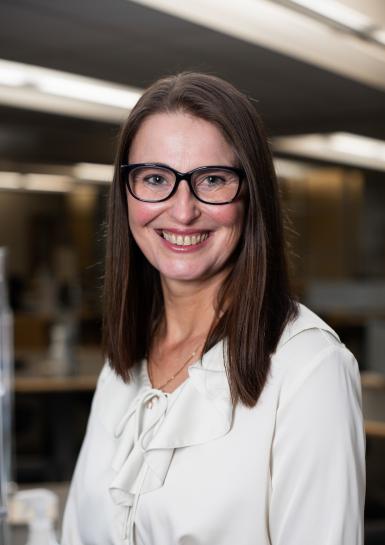 Photograph of a white female in her early 40s with medium length brown hair and glasses