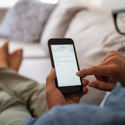 Sitting man reading email on smart phone